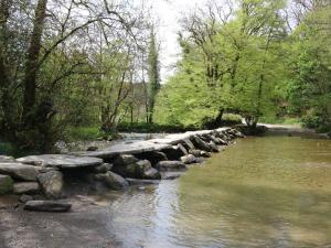 a stone bridge over a river in a park at 1 Tregonwell Court in Minehead +3 photos