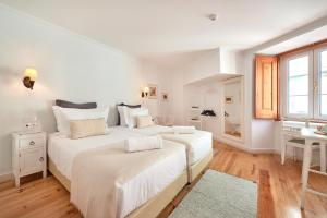a hotel room with a bed and a dresser at Casa do Mercado Lisboa in Lisbon