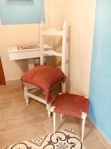 een kamer met een stoel, een tafel en een kruk bij Runamonte camere in Perugia