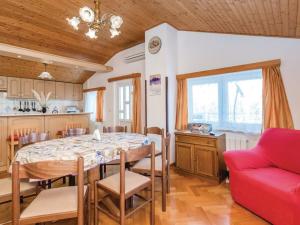 una cucina e una sala da pranzo con tavolo e divano rosso di Apartments Emil a Brseč (Bersezio)
