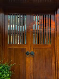 a pair of wooden doors on a house at Z&Z House in Rawai Beach