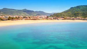 uma vista para uma praia com casas e o oceano em Sporting Hotel Stella Maris em Bosa Marina