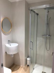 a bathroom with a sink and a glass shower at Pensión La Castellana in Logroño +29 photos