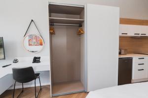 Habitación con armario, escritorio y silla. en Bridgewater Apartments by Century City Hotels en Ciudad del Cabo