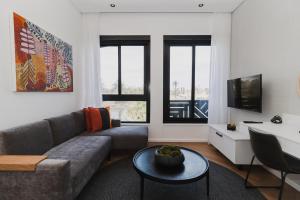 a living room with a couch and a tv at Bridgewater Apartments by Century City Hotels in Cape Town