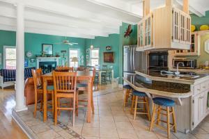 a kitchen with green walls and a table and chairs at Sweet Trade in Holden Beach