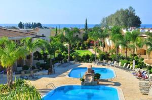 a resort with two pools and palm trees at 2 Bedroom Maisonette Mandria Paphos Cyprus in Paphos