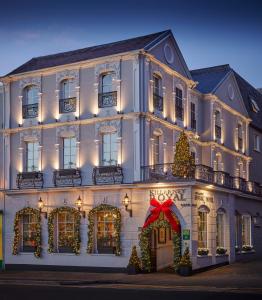 Um edifício branco com um jardim de Natal. em Killarney Royal Hotel em Killarney