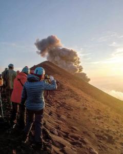 Un groupe de personnes prenant une photo d'un volcan dans l'établissement Stromboli Trekking Accommodation - Room and Excursion for 2 included, à Stromboli