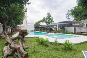a swimming pool in a yard next to a building at RedDoorz Plus @ Pakuan Residence Tajur in Bogor