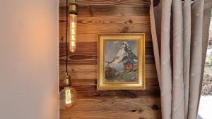Mattertal Lodge في Embd: لوحة على جدار خشبي عليها مصباحين