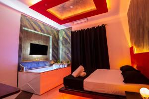 a bedroom with a bed and a tub and a television at Pompei Luxury Rooms in Pompei