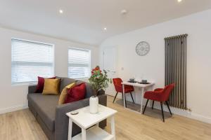 a living room with a couch and a table at Percy Place - Modern 1 bedroom ground floor apartment in central Southsea, Portsmouth in Southsea