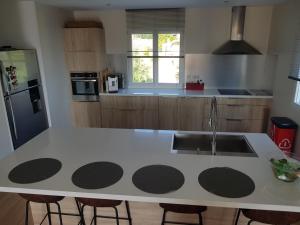 a kitchen with a white counter with a sink at VILLA CHJOSELLA 150M2 PISCINE ET AU CALME in Santa-Reparata-di-Balagna