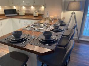 a wooden table with plates and wine glasses on it at Niche View in Irvine