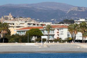 una ciudad con edificios, palmeras y montañas en MOTEL ASCOT - Hotel & Appartements, en Cagnes-sur-Mer
