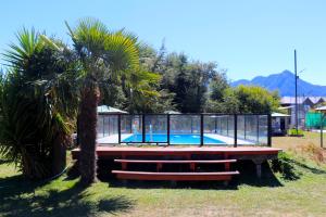 a swimming pool in a cage next to a palm tree at Cabañas Paihuén in Pucón