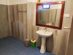 a bathroom with a sink and a mirror at Village Mango Resort Yala in Tissamaharama +106 photos