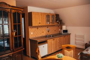 a kitchen with wooden cabinets and a sink at Apartmány Bartoš Vitanová in Vitanová
