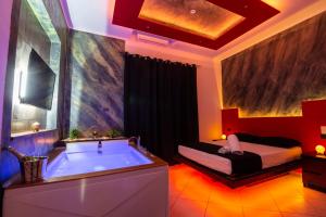 a bathroom with a tub and a bed in it at Pompei Luxury Rooms in Pompei