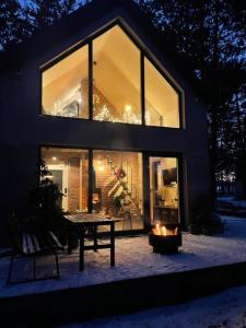 a house with a table and a fireplace in front of it at Stara Izba samotnia blisko natury in Aleksandria