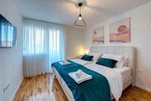 a bedroom with a large bed with two towels on it at Luxury apartment Olivia in Mostar