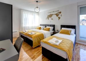 a bedroom with two beds and a map of the world on the wall at Luxury apartment Olivia in Mostar