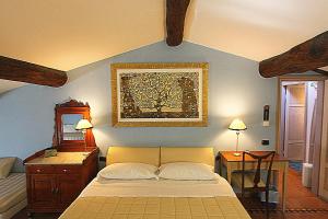 una camera da letto con un letto e un dipinto sul muro di Il Fiore all'Occhiello a Lucca