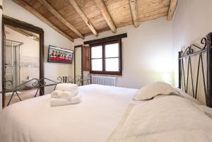 una camera da letto con un letto con lenzuola bianche e una finestra di Casa Sunalle a Fonni