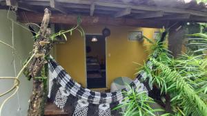 a hammock in theoyer of a house with plants at Guest House Boki da Zezé in Marau