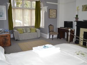 1 dormitorio con cama, sofá y escritorio en Owl House en Redruth