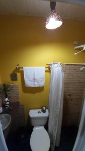 a bathroom with a white toilet and a sink at Guest House Boki da Zezé in Marau