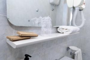 a bathroom with a shelf with towels and a mirror at Hotel Royal in Giulianova