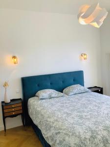 a bedroom with a blue bed with two pillows at Home Sweet Home in Cognac
