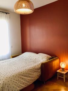 a bedroom with a bed and a red wall at Home Sweet Home in Cognac