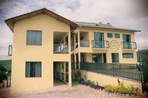 ein großes gelbes Gebäude mit Balkon in der Unterkunft Pousada Montanhas das Gerais in Pouso Alto