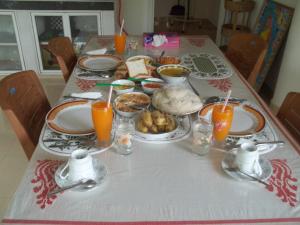 カルタラにあるAnura Home Stayの食べ物とオレンジジュースが入ったテーブル