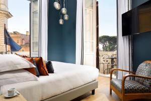 a bedroom with a bed and a tv and a chair at Dimora ai Fori - Guest House in Rome
