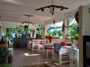 un restaurant avec des tables, des chaises et des fenêtres dans l'établissement Tabua Village Suite VIP, à Ribeira Brava