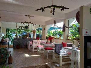 um restaurante com mesas, cadeiras e janelas em Tabua Village Suite VIP em Ribeira Brava