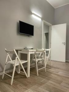 Zimmer mit einem Tisch und Stühlen sowie einem TV an der Wand in der Unterkunft Jr Suite MM3 Repubblica -Stazione-Centro Direz- C3 in Mailand