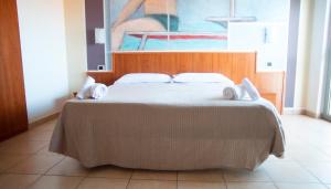a large bed in a room with a painting at Hotel Royal in Giulianova