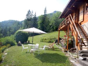 a table and chairs with an umbrella next to a house at PRA BIQUET in Les Thuiles +4 photos