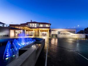 a building with a fountain in front of a building at Swan River Hotel in Perth