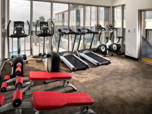 a gym with several tread machines in a room with windows at Swan River Hotel in Perth