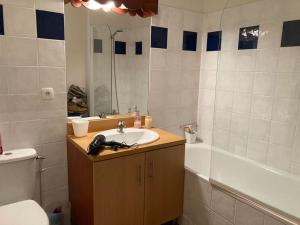 a bathroom with a sink and a toilet and a tub at Guzet Neige coeur station in Ustou