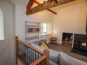 a living room with a couch and a fireplace at Guardswood Cottage in Coniston