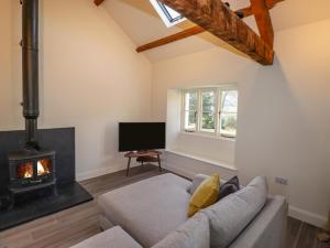 a living room with a couch and a fireplace at Guardswood Cottage in Coniston