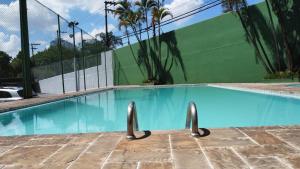 a swimming pool with blue water in front of a building at Pampas Palace Hotel in São Bernardo do Campo