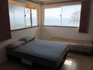 1 dormitorio con 2 camas y 2 ventanas en Pousada BarraVille en Barra Velha